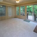 A picture of a sunroom leading to a porch